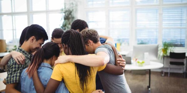 Group of business executives forming huddle Group of happy business executives forming huddle in office