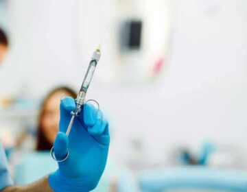 Dental anesthesia on the background of the patient Assistant dentist and the patient in the clinic.