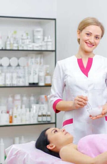 Young woman beautician is doing the cleaning procedure in the beauty salon. Face Skin Care. Cleansing Procedure. Cosmetology.