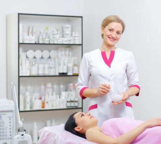 Young woman beautician is doing the cleaning procedure in the beauty salon. Face Skin Care. Cleansing Procedure. Cosmetology.